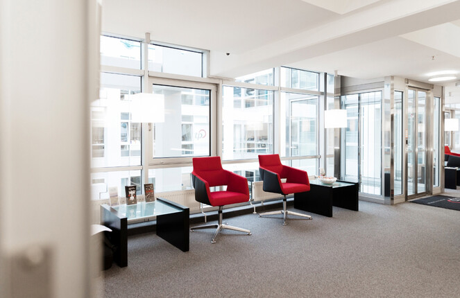 Rechteckiges Bild mit Blick auf zwei rote Stühle im ttp Büro
